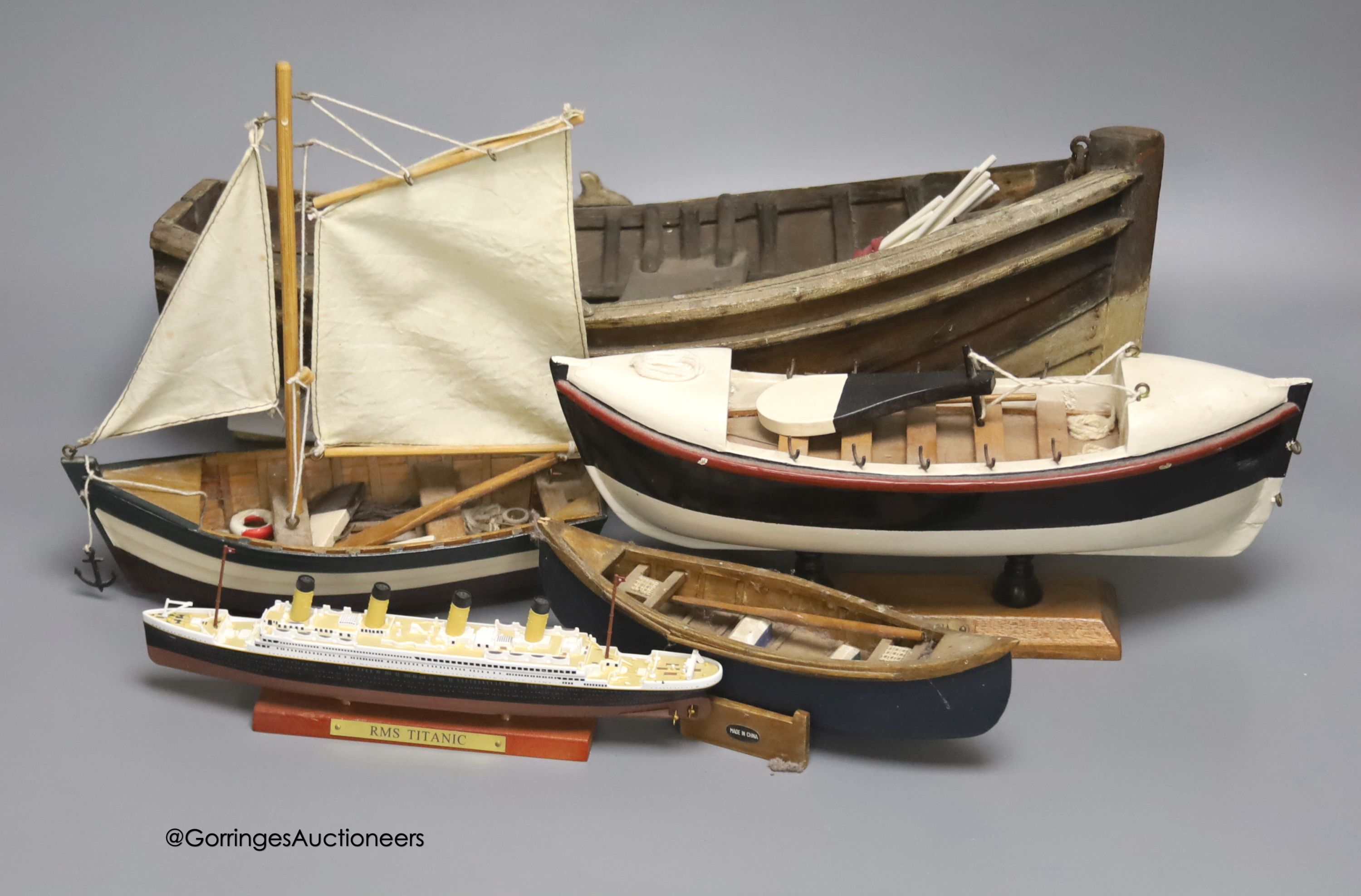 A clinker-built wood rowing boat, 41cm, and four smaller boat models